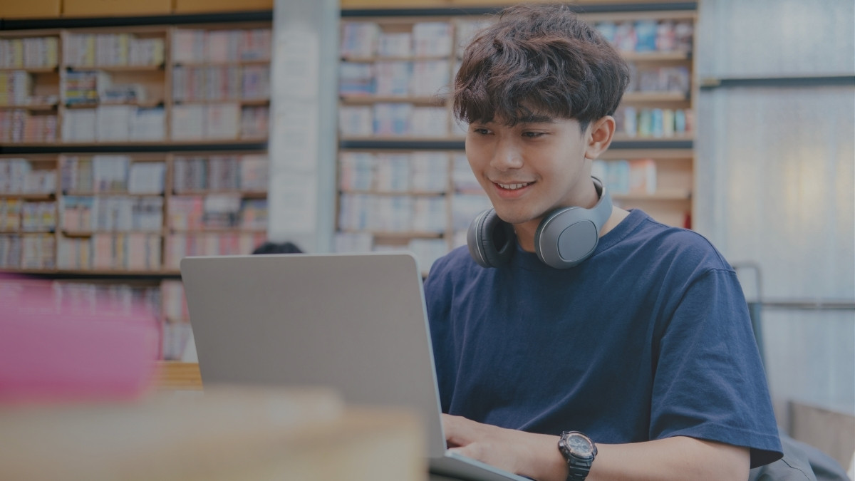 Estudiante utilizando una computadora portátil dentro de una biblioteca