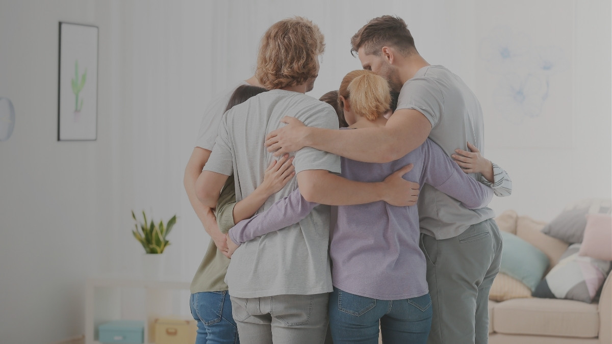 Familia compartiendo un abrazo de apoyo y tranquilidad dentro de su hogar
