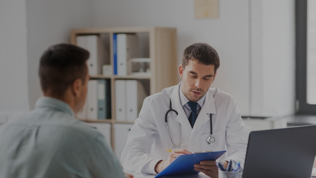 Médico revisando información durante una consulta privada con un paciente