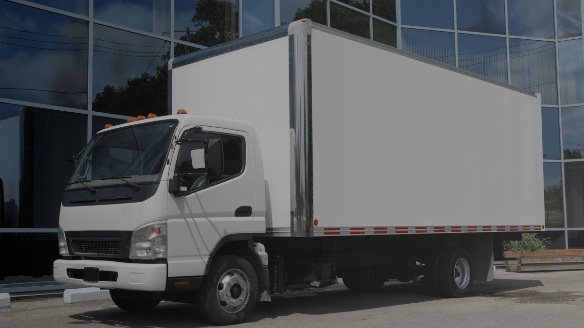 Camión de carga estacionado frente a un centro de distribución